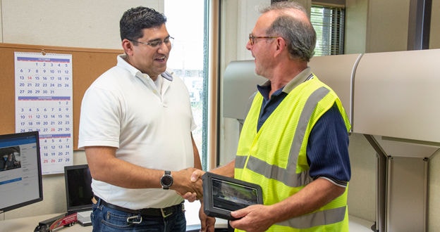 Manager and driver shaking hands in office
