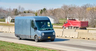 Business fleet delivery sprinter van on highway, dump truck in background 