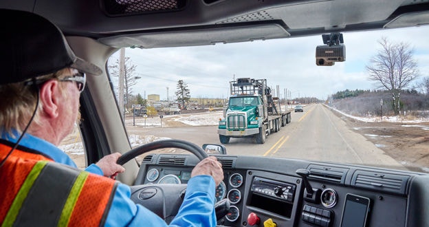 Driver driving with dash cam on windshield