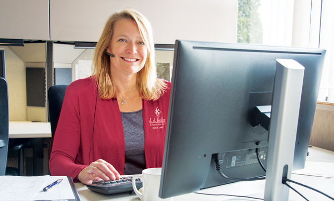 Person with headset at computer smiling