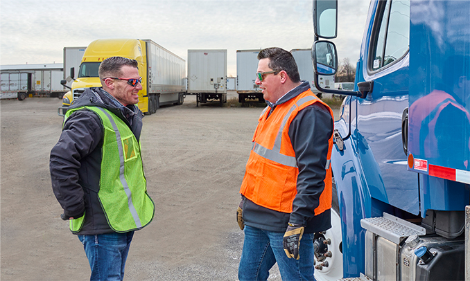 two people talking by truck in yard